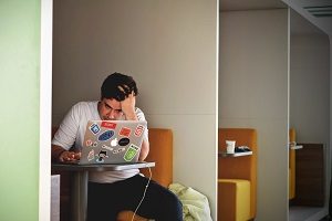 Frustrated man sitting infront of a laptop