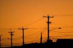 silhouettes of the power lines and wires in a residential neighborhood backlit by the evening sky HYu4Qv0ro